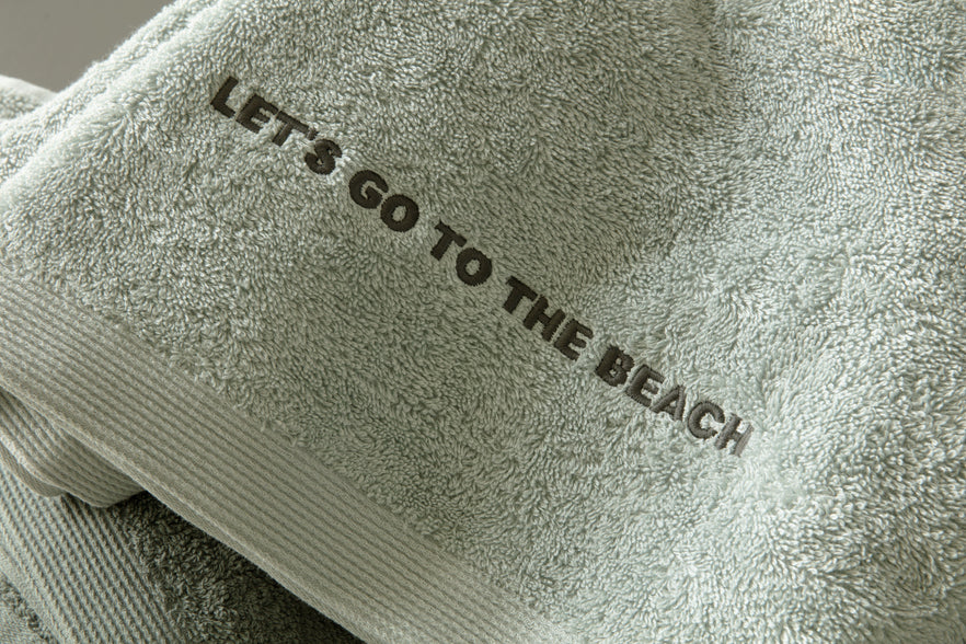 Strandlaken met tekst geborduurd